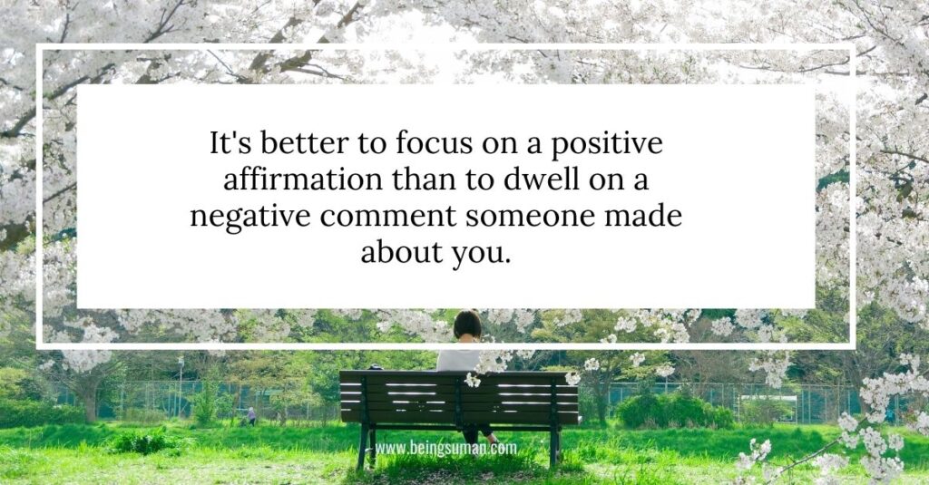 A person sitting on a bench in a park surrounded by cherry blossoms with a motivational quote overlay.